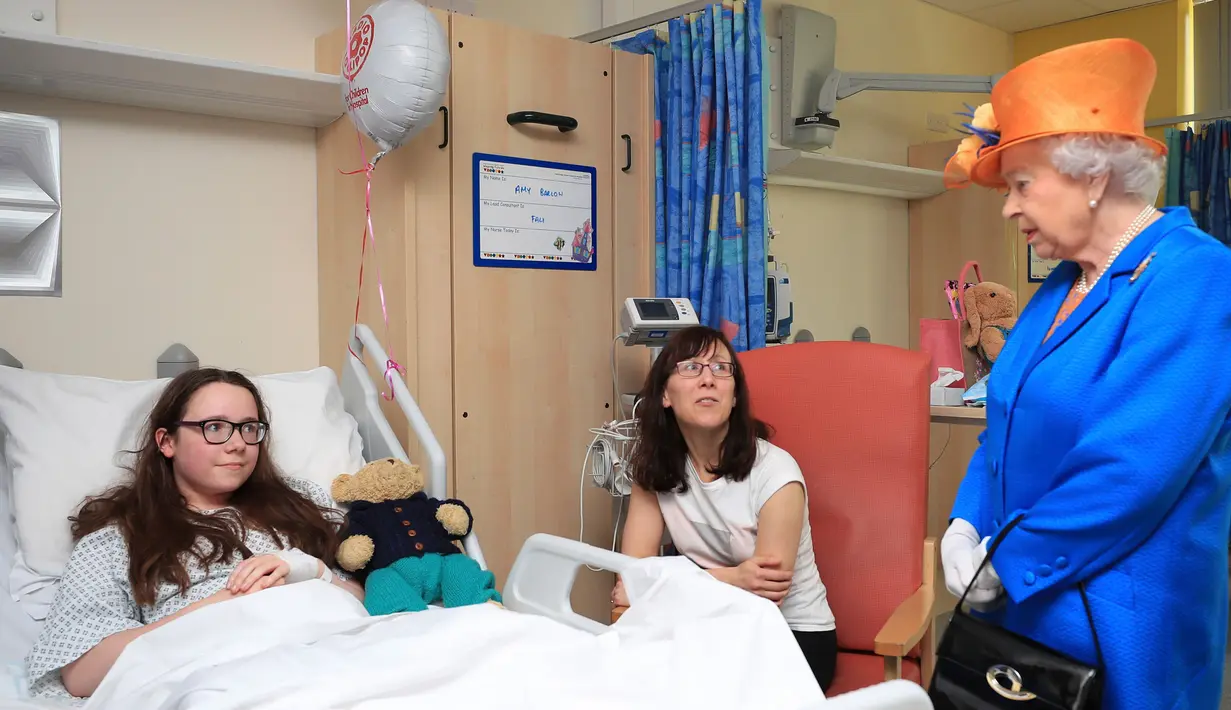 Ratu Elizabeth berbincang dengan Amy Barlow (12) dan ibunya saat mengunjungi korban bom konser Ariana Grande, di Rumah Sakit Anak Royal Manchester, Inggris, Kamis (25/5). Ada 14 pasien yang dirawat di RS tersebut. (Peter Byrne/Pool via AP)