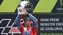 Pembalap Ducati, Andrea Dovizioso mengangkat trofi di podium setelah memenangi MotoGP Catalunya di sirkuit Barcelona Catalunya, Minggu (11/6). Dovizioso berhasil menyelesaikan balapan dengan catatan waktu tercepat 44 menit 41,518 detik. (Josep LAGO/AFP)