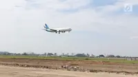 Sebuah pesawat melintas di atas proyek pembangunan runway dan taxiway 3 di Bandara Soekarno-Hatta, Tangerang, Kamis (21/6). Pembebasan lahan pembangunan runway di bandara Soetta sisi utara sudah mencapai 70 persen. (Liputan6.com/Angga Yuniar)