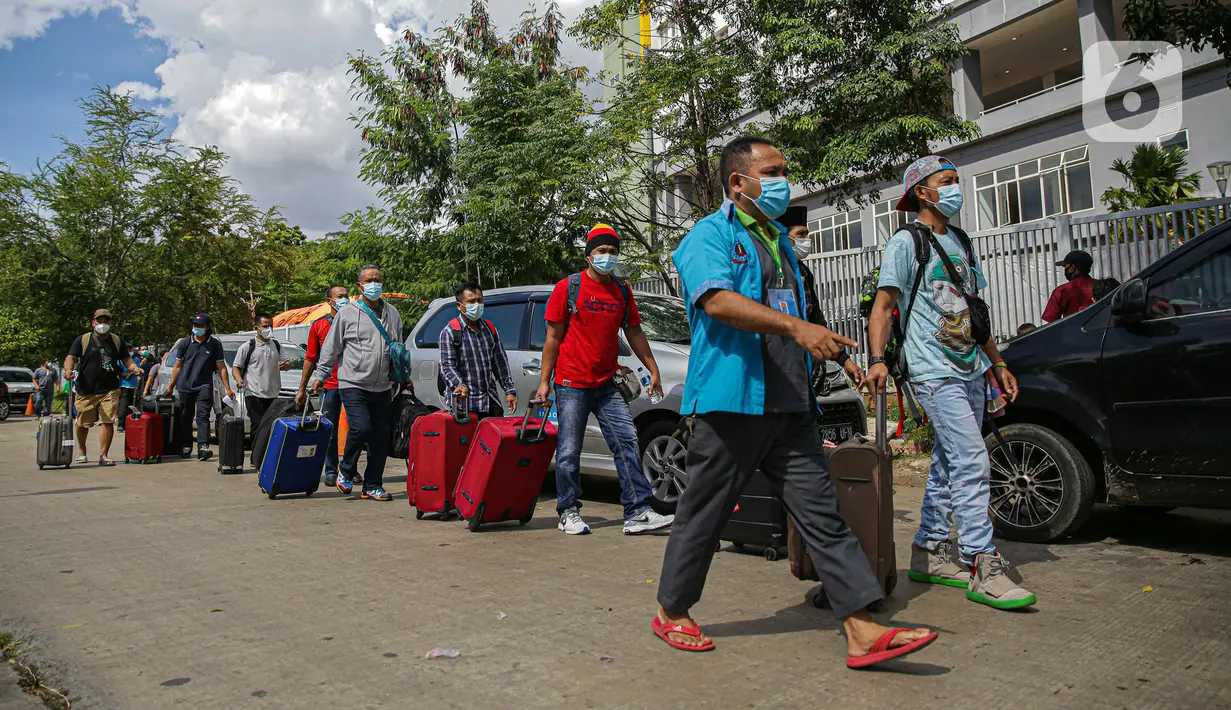 Warga negara Indonesia (WNI) membawa koper mereka usai menjalani isolasi di RSDC Wisma Atlet Pademangan, Jakarta, Selasa (15/6/2021). Pemerintah mewajibkan WNI yang baru tiba di Indonesia untuk melakukan isolasi selama lima hari guna menghindari penularan COVID-19. (Liputan6.com/Faizal Fanani)