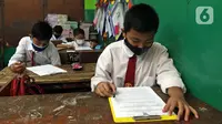Sejumlah murid SDN Kota Baru mengikuti ujian penilaian akhir sekolah di SDN Kota Baru 3 Bekasi, Jawa Barat, Senin (8/6/2021). Ujian dibagi dua sesi, jam 7.00 WIB - 9.00 WIB dan 9.30 - 11.00 WIB. (Liputan6.com/Herman Zakharia)