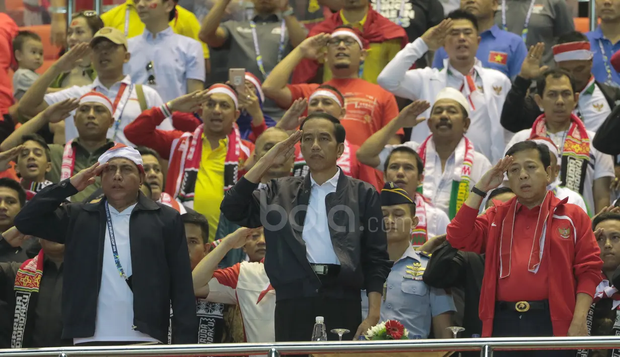 Presiden Republik Indonesia, Joko Widodo melakukan penghormatan saat lagi Indonesia Raya dikumandangkan pada laga Semi-final AFF Cup 2016 di Stadion Pakansari, Bogor, (03/12/2016). (Bola.com/Nicklas Hanoatubun)