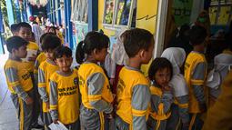 Para siswa mengantre untuk menerima vaksin difteri di sebuah sekolah dasar di Surabaya pada Selasa 4 November 2025. Program yang menyasar seluruh siswa SD, MI, SMP, dan MTs di Kota Surabaya dan dilaksanakan secara gratis di sekolah masing-masing oleh tim dari Puskesmas setempat. (Juni KRISWANTO/AFP)
