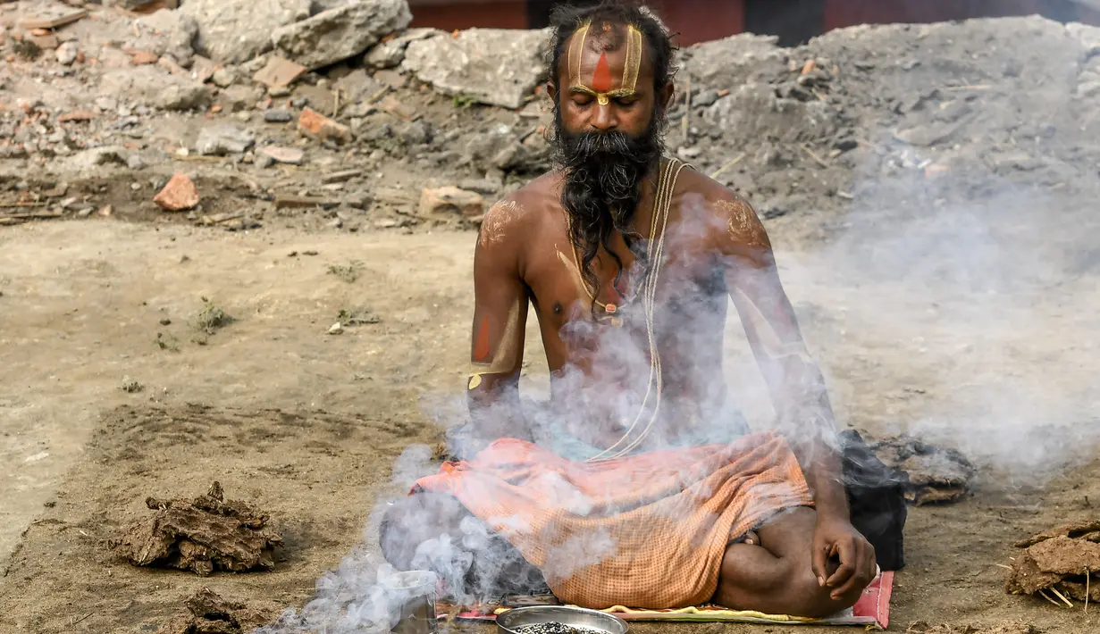 Seorang sadhu (orang suci Hindu) melakukan ritual selama festival Hindu 'Maha Shivaratri' di Kathmandu (20/2/2020). Festival ini  didedikasikan untuk 'Malam Besar Siwa', dewa Hindu yang berdoa dan berpuasa bagi orang percaya. (AFP/Prakash Mathema)