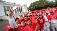 Sejumlah atlet berselfie saat berada di depan Istana Merdeka sebelum acara pelepasan kontingen sea games di Istana Merdeka, Jakarta, Selasa (26/5/2015). Indonesia menurunkan 522 atlet yang berlaga di 32 cabang olah raga. (Liputan6.com/Faizal Fanani)
