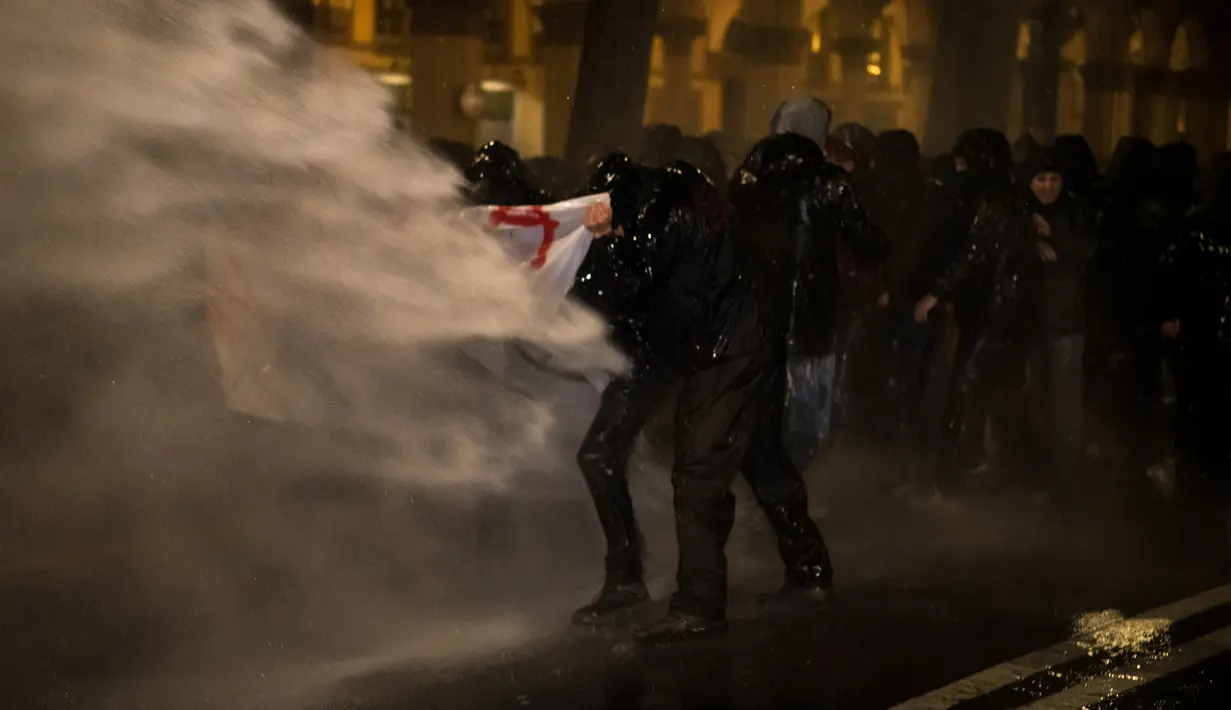 Petugas keamanan setempat menembakan meriam air ke arah aktivis antifasis yang menggelar demonstrasi di Turin, Italia (22/2). (AFP Photo/Piero Cruciatti)