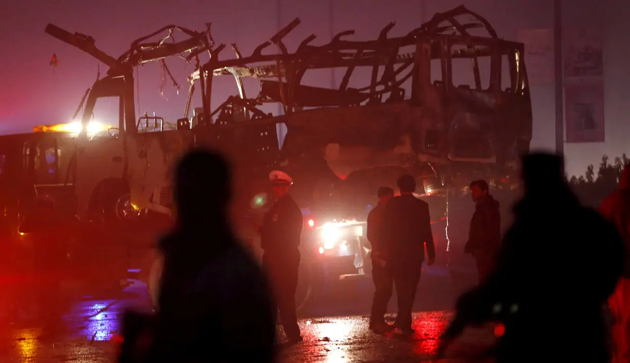 Polisi Afghanistan berjaga-jaga di dekat bangkai minibus yang meledak di dekat Kedubes Rusia di Kabul, Rabu (20/1). Ledakan itu menimbulkan asap hitam, sementara ambulans dan mobil pemadam kebakaran segera dikerahkan ke lokasi. (REUTERS/Omar Sobhani)