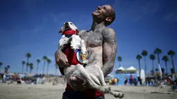 Ryan Rustan tertawa bersama anjingnya usai berlaga di Surf Dog Contest Surf City di Huntington Beach, California, Amerika Serikat, (27/9/2015). (REUTERS/Lucy Nicholson)