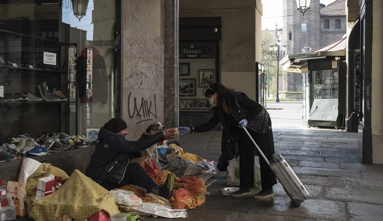 Lucetta Boles Carenini memberikan makanan kepada tunawisma di Turin, Italia, 3 April 2020. Menurut Departemen Perlindungan Sipil Italia pada 6 April 2020, jumlah kasus virus corona COVID-19 di negara tersebut menjadi 132.547 infeksi, 16.523 meninggal, dan 22.837 sembuh. (MARCO BERTORELLO/AFP)