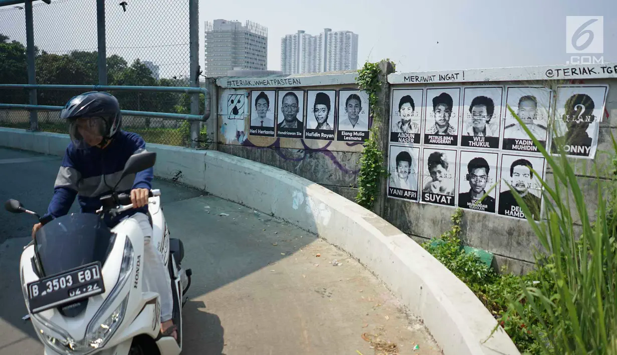 Pengendara sepeda motor melintas di depan poster 13 aktivis yang hilang di kawasan Beji, Depok, Jawa Barat, Selasa (18/6/2019). Poster tersebut mengingatkan masyarakat masih ada pekerjaan rumah pemerintah berupa pelanggaran HAM berat yang belum tuntas hingga kini. (Liputan6.com/Immanuel Antonius)