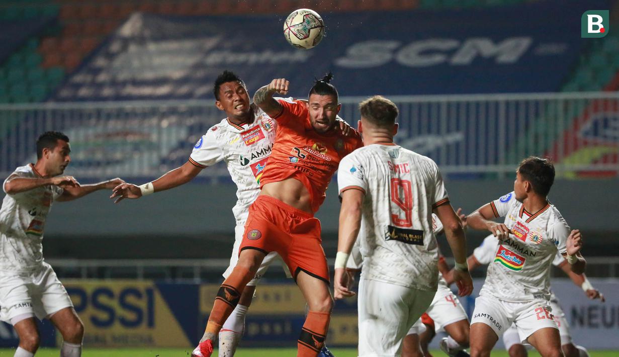 Pemain Persija Jakarta, Maman Abdurrahman (tengah) berduel udara dengan pemain Persiraja Banda Aceh, Vanja Markovic dalam laga pekan ke-6 BRI Liga 1 2021/2022 di Stadion Pakansari, Bogor, Sabtu (10/2/2021). Persija menang 1-0. (Bola.com/M Iqbal Ichsan)