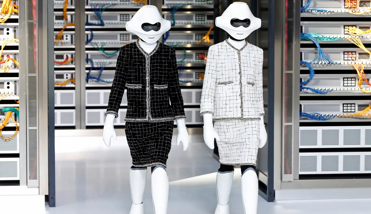 Dua robot berjalan di catwalk membawakan rancangan desainer Karl Lagerfeld untuk koleksi musim semi 2017 di Paris Fashion Week, Prancis, Selasa (4/10). Kedua robot memakai setelan klasik Chanel dengan warna hitam dan putih. (REUTERS/Charles Platiau)