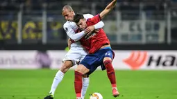 Duel antara Andrija Pavlovic dan Miranda pada leg 2, babak 16 besar Liga Europa yang berlangsung di stadion Giuseppe Meazza, Milan, Jumat (22/2). Inter Milan menang 4-0 atas rapid Wien. (AFP/Miguel Medina)