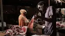 Pedagang memotong ikan di sebuah pasar ikan di dekat Sungai Nil, di kota kembar Khartoum, Omdurman (24/6/2019). Khartoum memiliki iklim tandus yang panas, hanya pada bulan Juli dan Agustus memiliki presipitasi yang signifikan. (AFP Photo/Yasuyoshi Chiba)