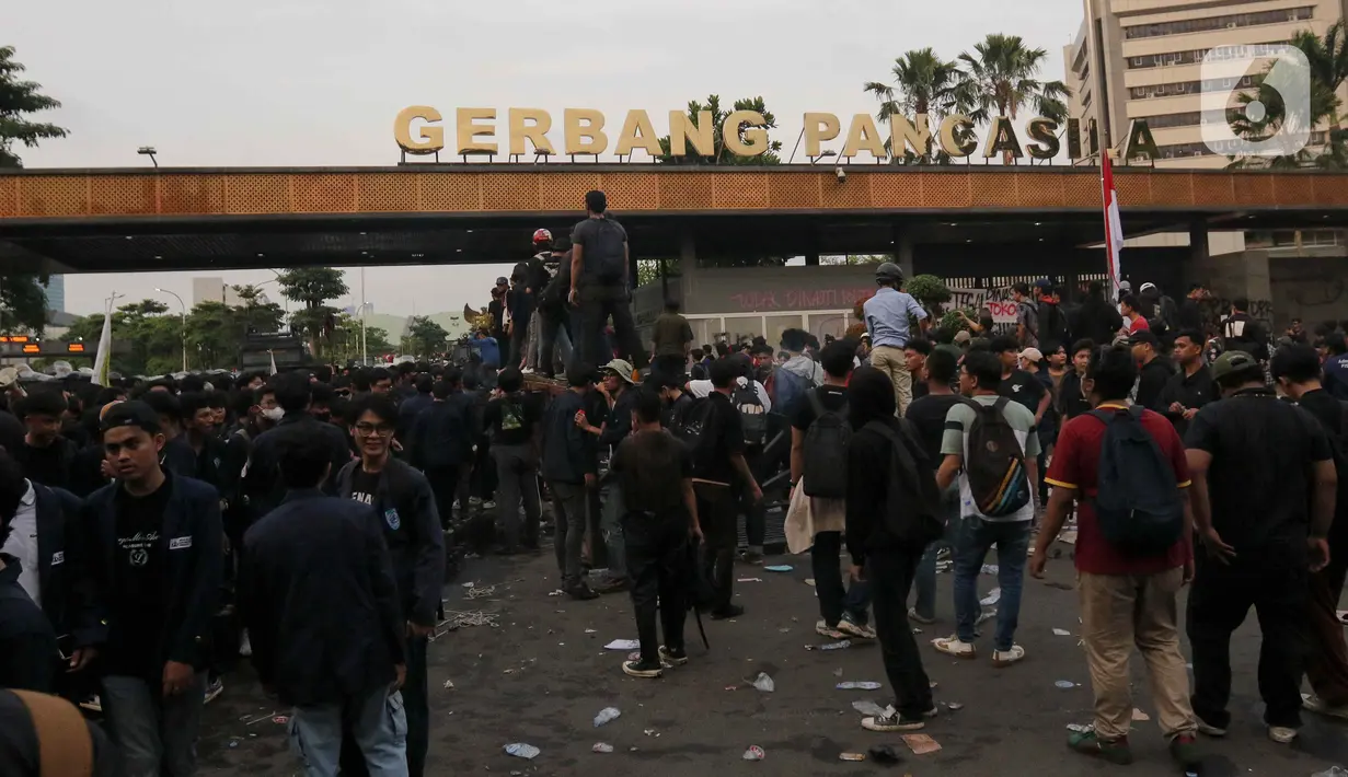 Setelah merobohkan pintu pagar Gerbang Pancasila, pengunjuk rasa berkumpul dengan penjagaan ketat dari pihak kepolisian. (Liputan6.com/Herman Zakharia)