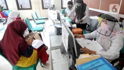 Petugas Dinas Kependudukan dan Catatan Sipil menggunakan pelindung wajah saat melayani warga di Kecamatan Pamulang, Tangerang Selatan, Rabu (3/6/2020). Sejumlah kantor pelayanan pemerintah melaksanakan protokol kesehatan yang ketat untuk memutus rantai penyebaran covid-19. (merdeka.com/Arie Basuki)