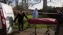 Petugas memasukkan jasad pria yang tewas usai membakar diri ke dalam ambulans, di dekat Istana Kensington, London, Inggris, Selasa (9/2). Pria 40 tahun itu membakar diri di dekat tempat tinggal Pangeran Willian dan Kate Middleton. (REUTERS/Neil Hall)