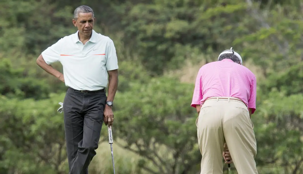 Presiden AS Barack Obama memperhatikan PM Malaysia, Najib Razak melakukan put di lubang ke 18 saat bermain golf di Hawaii, Rabu (24/12/2014). (AFP PHOTO/Nicholas KAMM)