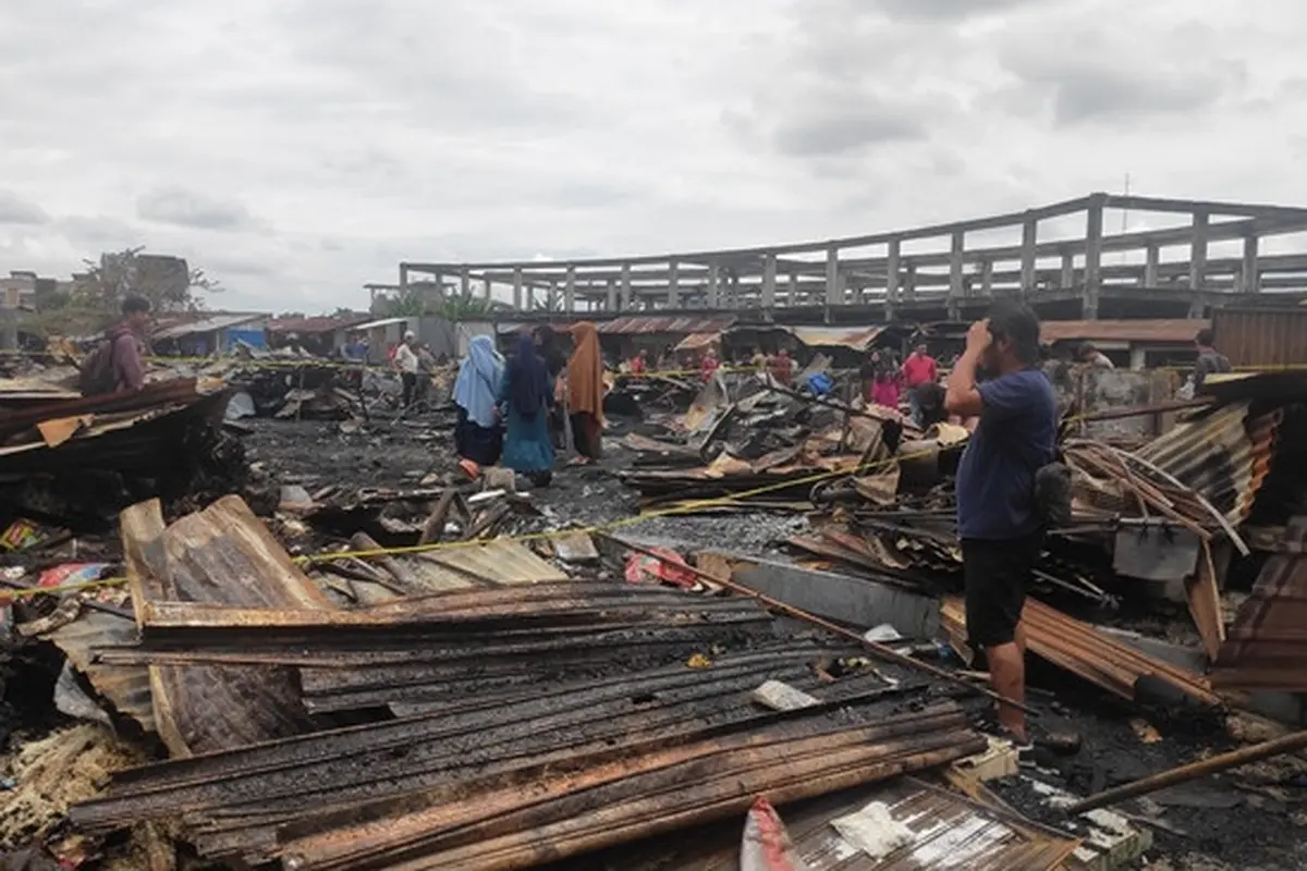 Salah satu pedagang di Pasar Cik Puan Pekanbaru melihat bekas kiosnya yang terbakar.