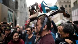 Seorang pria memakai topi yang terbuat dari sepatu wanita dalam Parade Paskah tahunan dan Festival Bonnet di sepanjang Fifth Avenue, New York, AS, Minggu (21/4). Parade Bonnet Easter merupakan parade pada perayaan Paskah di Kota New York yang sudah ada sejak tahun 1870. (Johannes EISELE / AFP)
