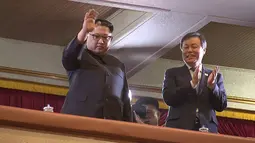 Pemimpin Korea Utara Kim Jong-Un (kiri) menyapa hadirin yang datang saat konser yang menampilkan sejumlah musisi dari Korea Selatan di East Pyongyang Grand Theatre, Korea Utara (4/1). (AFP Photo/Korea Pool)