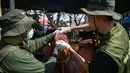 Petugas kesehatan dari Dinas Ketahanan Pangan dan Pertanian memeriksa mulut sapi di pasar ternak menjelang Idul Adha atau hari raya kurban bagi umat Muslim, di Surabaya, Jawa Timur, pada Rabu 20 Mei 2026. (JUNI KRISWANTO/AFP)