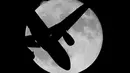 Siluet pesawat pada saat fenomena Supermoon yang muncul di atas langit Ronda, Spanyol, Senin (17/10). Dalam fenomena tersebut, bulan purnama terlihat lebih besar dan terang karena berada di jarak terdekat dengan bumi. (Reuters/Jon Nazca)
