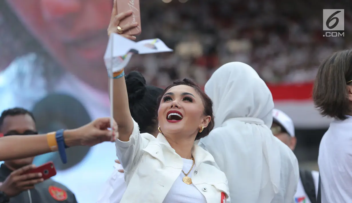 Penyanyi Yuni Shara berselfie saat menghadiri kampanye akbar pasangan Capres dan Cawapres nomor urut 01, Jokowi - Ma'ruf Amin bertajuk 'Konser Putih Bersatu di Stadion Gelora Bung Karno (SGBK), Jakarta, Sabtu (13/4). (Kapanlagi.com/Budi Santoso)