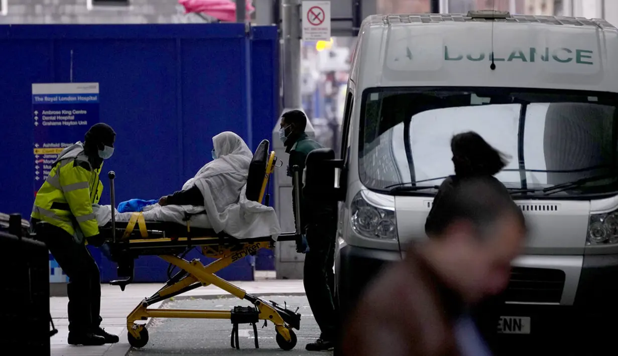 Seorang pasien didorong menggunakan troli di luar Rumah Sakit Royal London, Inggris, 6 Januari 2022. Inggris memangkas waktu isolasi pasien COVID-19 dari 10 menjadi 7 hari karena kekurangan tenaga kesehatan akibat lonjakan kasus yang dipicu Omicron. (AP Photo/Matt Dunham)