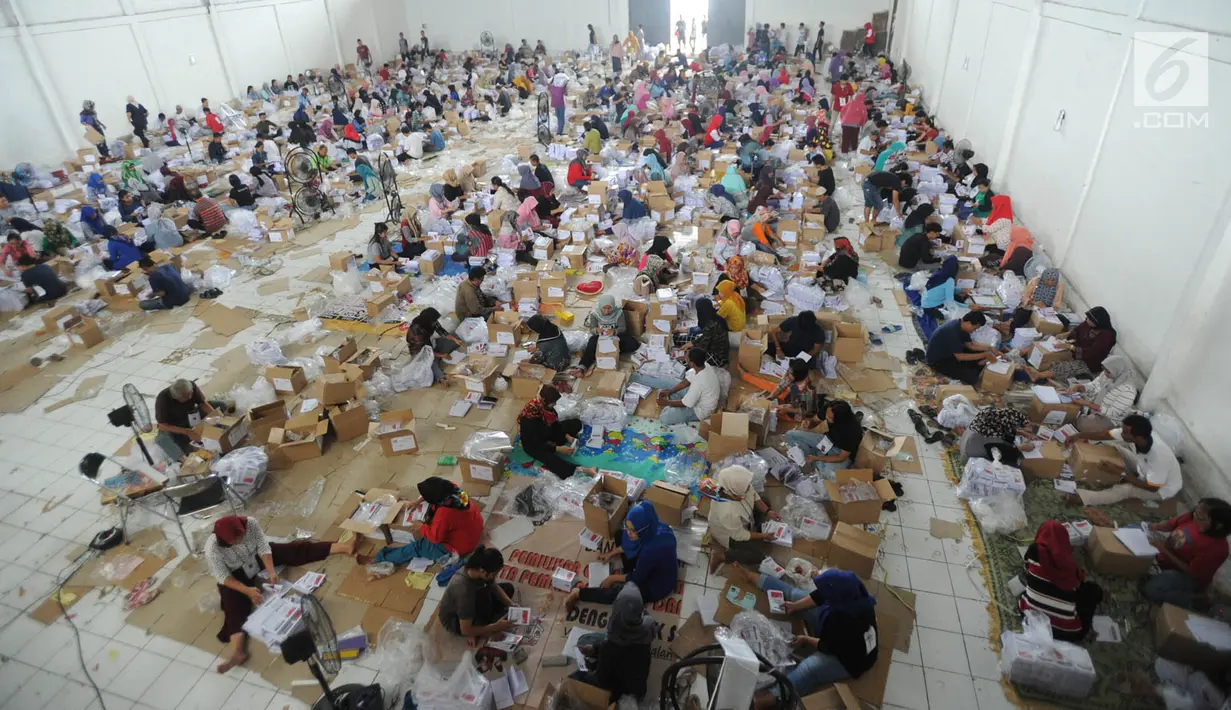 Relawan menyortir dan melipat kertas suara Pilpres 2019 di gudang KPU, Cibinong, Bogor, Kamis (7/3). Libur Nyepi, dimanfaatkan 650 pekerja menyelesaikan tenggat waktu penyortiran dan pelipatan 17 juta surat suara Pemilu 2019. (merdeka.com/Arie Basuki)