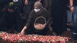 Adriyanti Firdasari, mantan pebulutangkis tunggal putri pelatnas PBSI yang juga sahabat dari Markis Kido memberikan penghormatan terakhir dengan menaburkan bunga. (Foto: Bola.com/Erwin Fitriansyah)