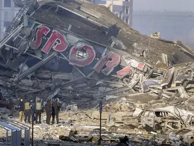 Orang-orang memeriksa kerusakan setelah serangan sebuah pusat perbelanjaan di Kiev, Ukraina, Senin (21/3/2022). Delapan orang tewas dalam serangan tersebut. (AP Photo/Efrem Lukatsky)