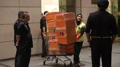 Polisi Malaysia membawa tas mewah yang disita dalam penggeledahan di tiga apartemen mantan Perdana Menteri, Najib Razak di Kuala Lumpur, Jumat (18/5). Polisi menyita 284 tas tangan mewah termasuk Hermes dan Birkin. (ARIFFIN JAMAR/THE STRAITS TIMES/AFP)