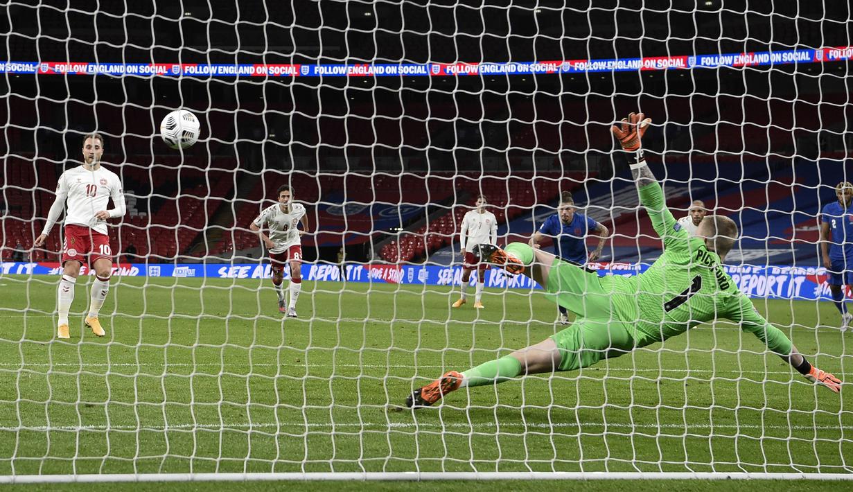 Pemain Denmark Christian Eriksen (kiri) mencetak gol ke gawang Inggris dari titik penalti pada pertandingan UEFA Nations League di Stadion Wembley, London, Inggris, Rabu (14/10/2020). Denmark menang 1-0. (Daniel Leal-Olivas/Pool via AP)