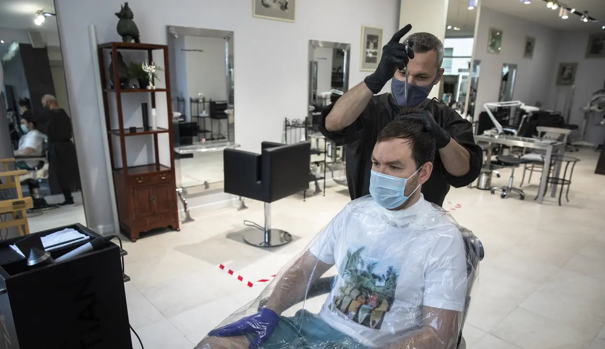 Tukang cukur menata rambut kliennya pada hari pertama berakhirnya lockdown di salon kecantikan Persona, Moskow, Rusia, Selasa (9/6/2020). Warga Moskow bebas beraktivitas setelah dua bulan menjalani lockdown akibat pandemi virus corona COVID-19. (AP Photo/Pavel Golovkin)
