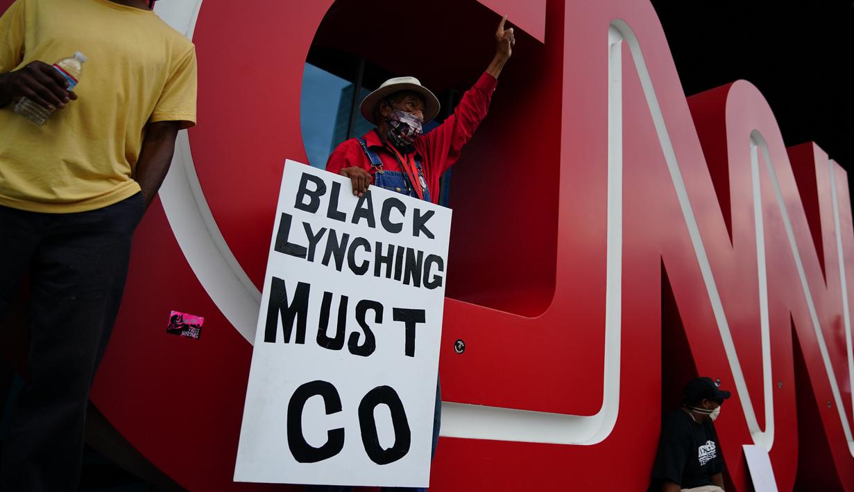 Orang-orang menggelar aksi protes di kantor pusat CNN di Atlanta, Georgia, Jumat (29/5/2020). Massa yang mengecam kematian George Floyd (46) oleh polisi melakukan vandalisme dan perusakan gedung CNN pusat. (Elijah Nouvelage/Getty Images/AFP)
