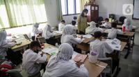 Guru mengajar murid di SDN Cibubur 04, Jakarta, Jumat (13/5/2022). Kegiatan belajar di sekolah yang mencakup wilayah DKI Jakarta, Banten, dan Jawa Barat kembali dimulai pascalibur Lebaran. (Liputan6.com/Faizal Fanani)