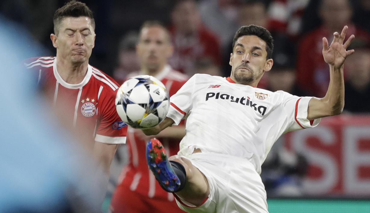 Pemain Bayern, Robert Lewandowski (kiri) berebut bola dengan pemain Sevilla, Jesus Navas pada leg kedua perempat final Liga Champions di Allianz Arena stadium, Munich, (11/4/2018). Bayern lolos ke semifinal dengan agregat 2-1. (AP/Matthias Schrader)