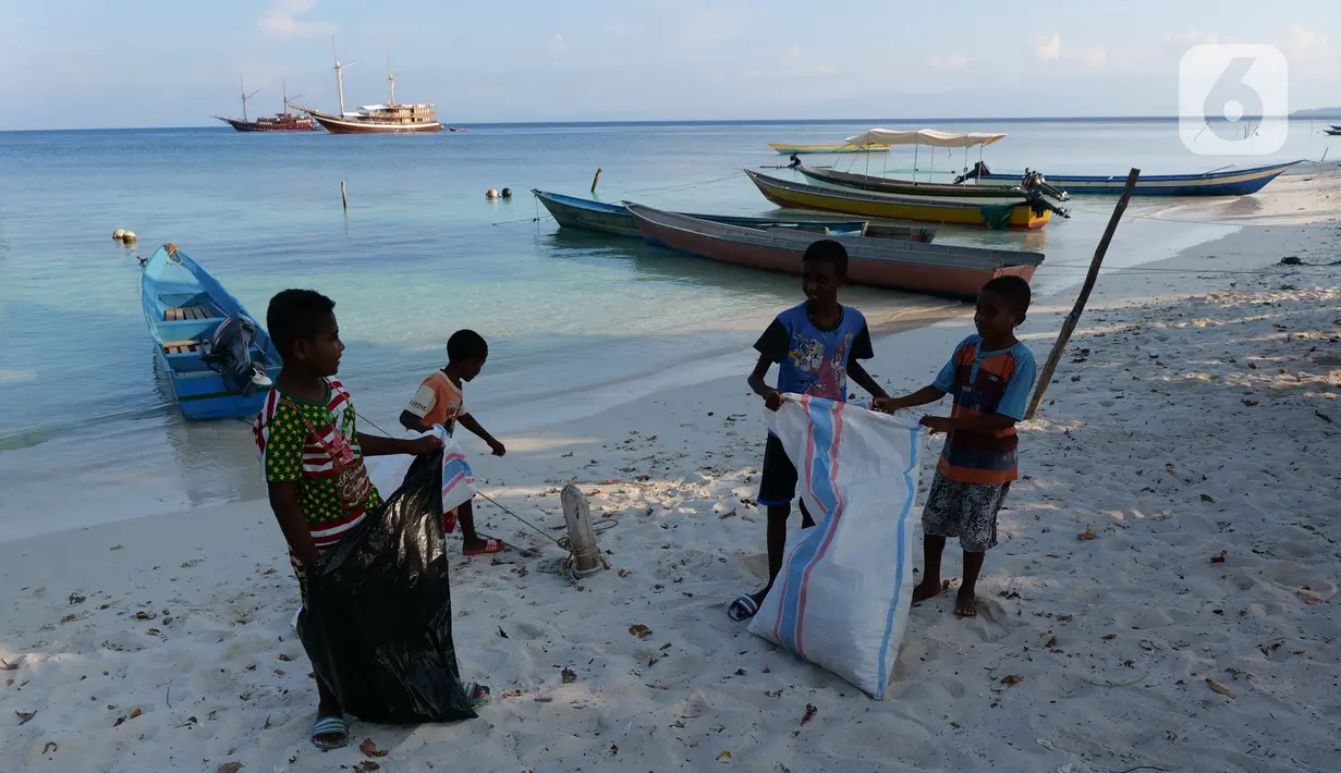 Beberapa anak membersihkan sampah plastik yang ada di bibir pantai Desa Sawandarek, Raja Ampat, Papua Barat, Jumat (22/11/2019). Aksi membersihkan sampah plastik ini, digagas Carrie, aktivis asal Amerika Serikat,  yang sudah menetap di Indonesia selama 3 tahun. (Liputan6.com/Herman Zakharia)