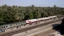 Sejumlah gerbong kereta penumpang keluar jalur usai tergelincir saat melintasi jalur di daerah al-Badrasheen, Giza, Mesir, (13/7). Dalam kejadian tersebut, tidak ada korban jiwa dan sekitar 55 penumpang terluka. (AFP Photo/Stringer)