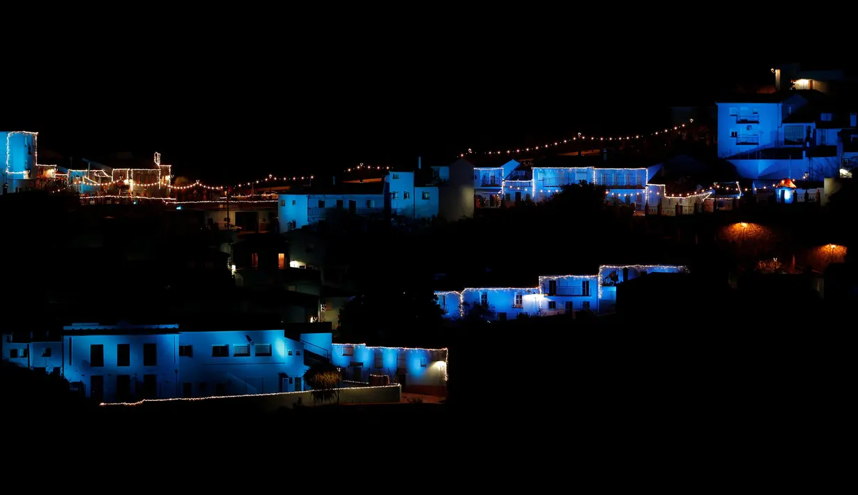 Lampu berwarna biru dinyalakan untuk menandai awal musim Natal di Juzcar, Selatan Spanyol, 2 Desember 2016. Semua bangunan di desa ini sengaja dicat berwarna biru untuk mempromosikan premier film baru "Smurfs: the lost village". (REUTERS/Jon Nazca)