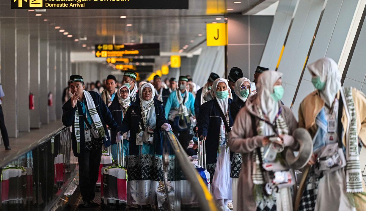 Sebanyak 380 orang calon jemaah haji (termasuk petugas) asal Kabupaten Probolinggo menjadi rombongan pertama yang berangkat ke Tanah Suci. Tampak dalam foto, jemaah haji Indonesia berjalan menuju gerbang keberangkatan Bandara Internasional Juanda, Sidoarjo, Jawa Timur, Rabu 22 April 2026. (JUNI KRISWANTO/AFP)