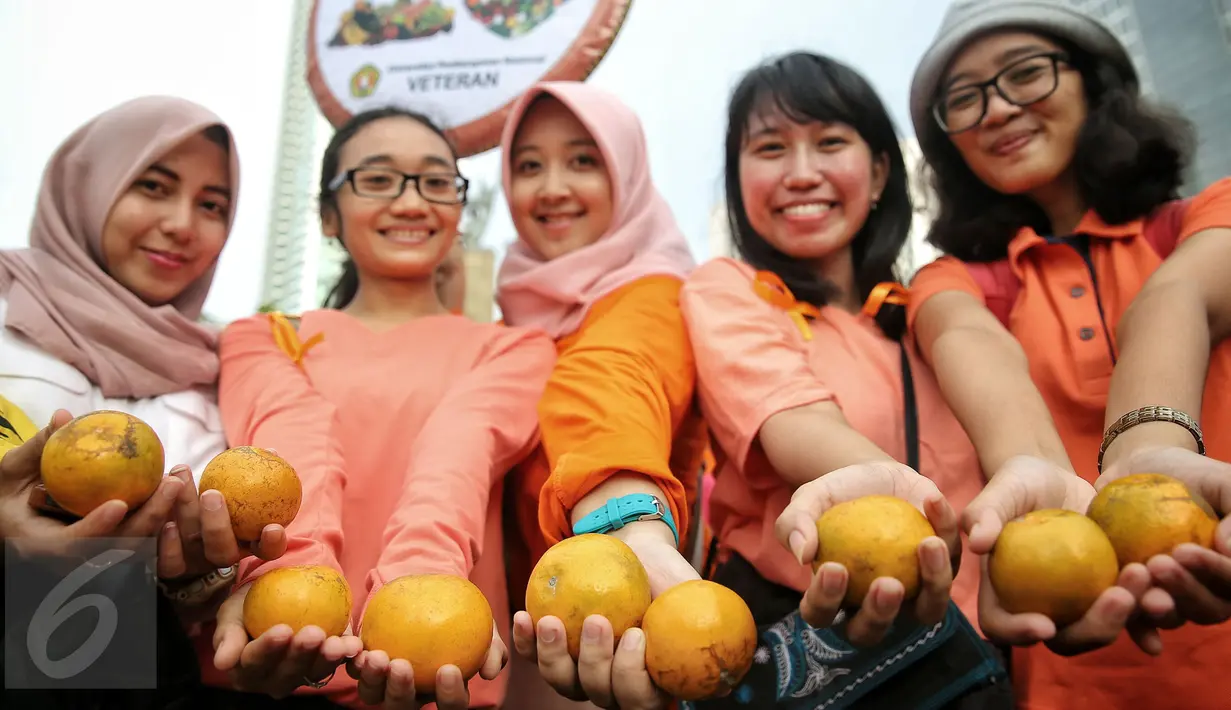 Peserta aksi menunjukan pentingnya buah untuk gizi dalam aksi peringati Hari Gizi Nasional di kawasan Bunderan HI, Jakarta, (31/2/2015). Dalam aksinya memberikan memberitahukan pentingnya sayur mayur diberikan untuk anak. (Liputa6.com/Faizal Fanani)