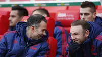 Asisten pelatih MU, Ryan Giggs tertawa bersama Wayne Rooney saat berada di bangku cadangan kala MU bertanding melawan Stoke. (Reuters/Carl Recine)