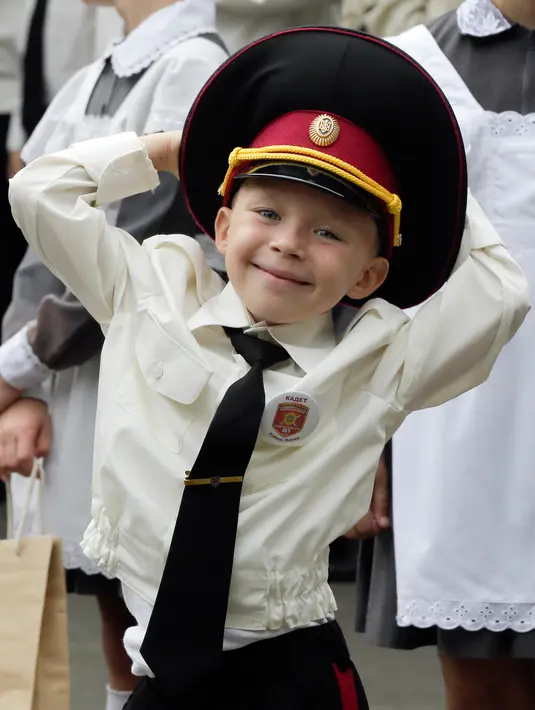 Seorang taruna muda tersenyum ketika menghadiri upacara pada hari pertama sekolah di salah satu sekolah Kadet terbaik, lyceum, di Kiev, Senin (3/9). Ukraina menandai Hari Pengetahuan, sebagai dimulainya tahun ajaran baru. (AP Photo/Efrem Lukatsky)