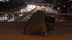 Tenda seorang tunawisma berdiri di atas jembatan di atas 110 Freeway di Los Angeles, Rabu (14/12/2022). Tenda-tenda mereka menjadi saksi tentang kemiskinan besar yang ada di kota, yang pada saat yang sama juga merupakan kota yang kaya. (AP Photo/Jae C. Hong)
