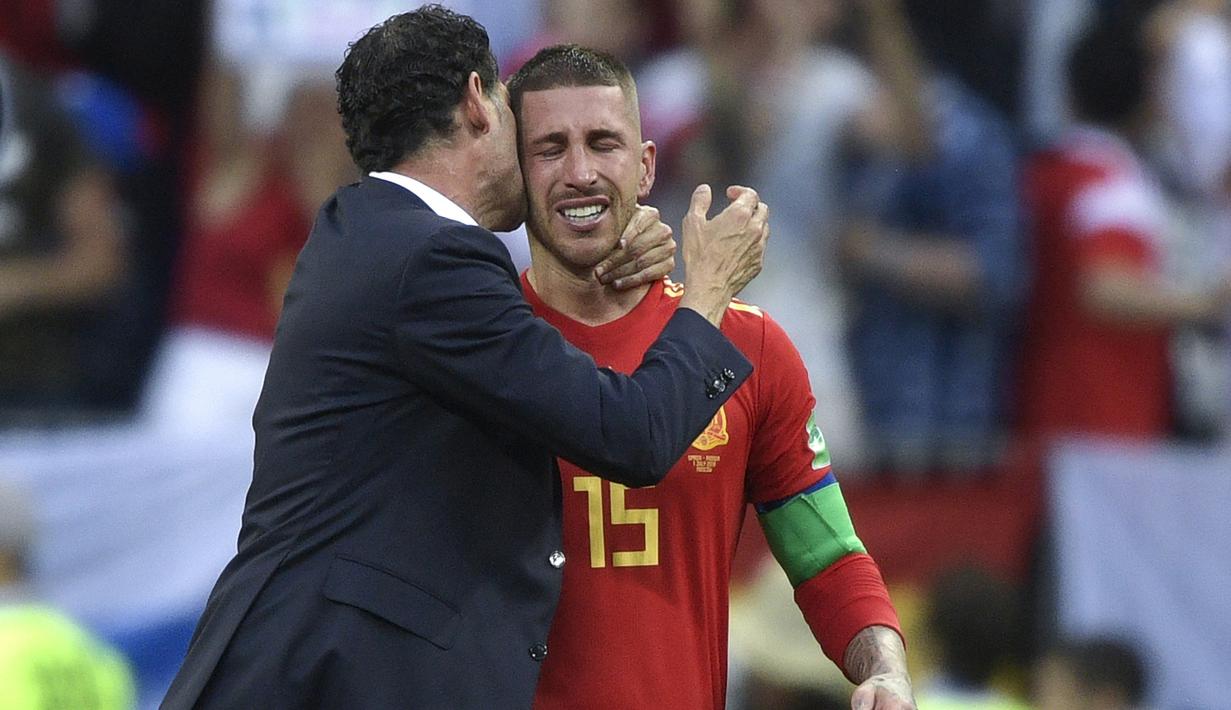Tangis Sergio Ramos (kanan) pecah saat memeluk pelatih, Fernando Hierro usai kalah dari Rusia pada laga 16 besar Piala Dunia 2018 di Luzhniki Stadium, Moskow, Rusia, (1/7/2018). Spanyol kalah adu penalti 3-4. (AFP/Juan Mabromata)
