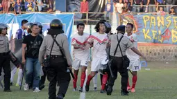 Pemain Persis Solo, Rico Fernanda diamankan petugas setelah terlibat keributan dalam final lanjutan Piala Polda Jateng di Stadion Jatidiri, Semarang, Minggu (2/8/2015). (Bola.com/Vincensius Sawarno)