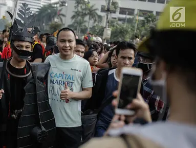 Warga berfoto dengan para peserta parade seni budaya Kepulauan Nias saat Car Free Day di Kawasan Jalan Sudirman, Jakarta, Minggu (4/3). (Liputan6.com/Faizal Fanani)