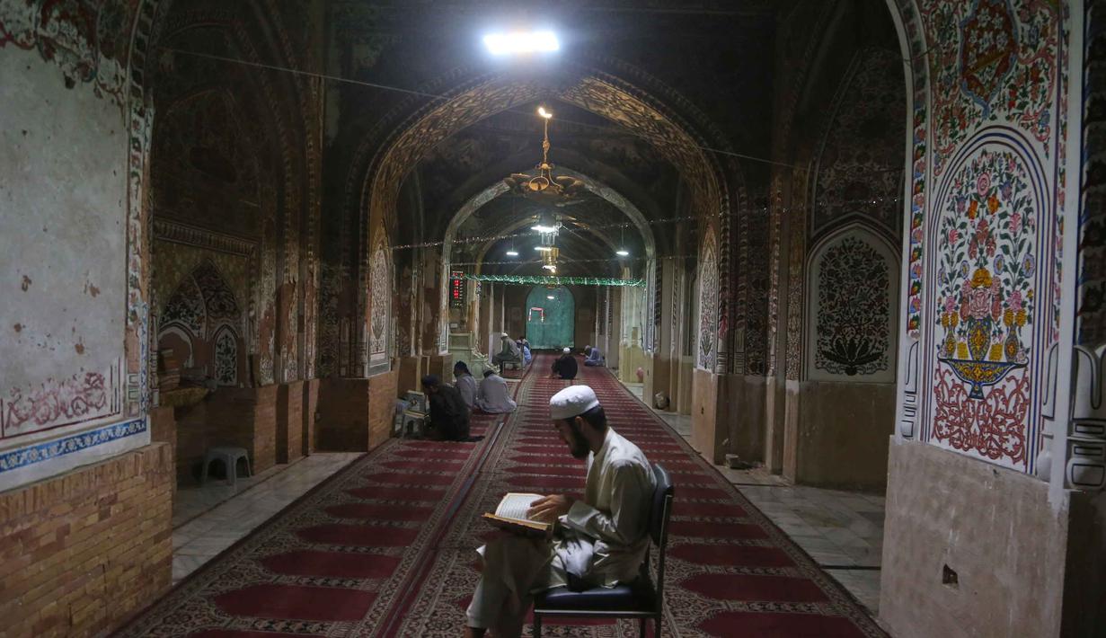 Umat Muslim membaca kitab suci Al Quran saat mereka melaksanakan Itikaf, selama sepuluh hari terakhir bulan Ramadan, di salah satu masjid, di Peshawar, Pakistan, Selasa 10 Maret 2026. Ramadan merupakan bulan mulia penuh berkah. (AP Photo/Muhammad Sajjad)